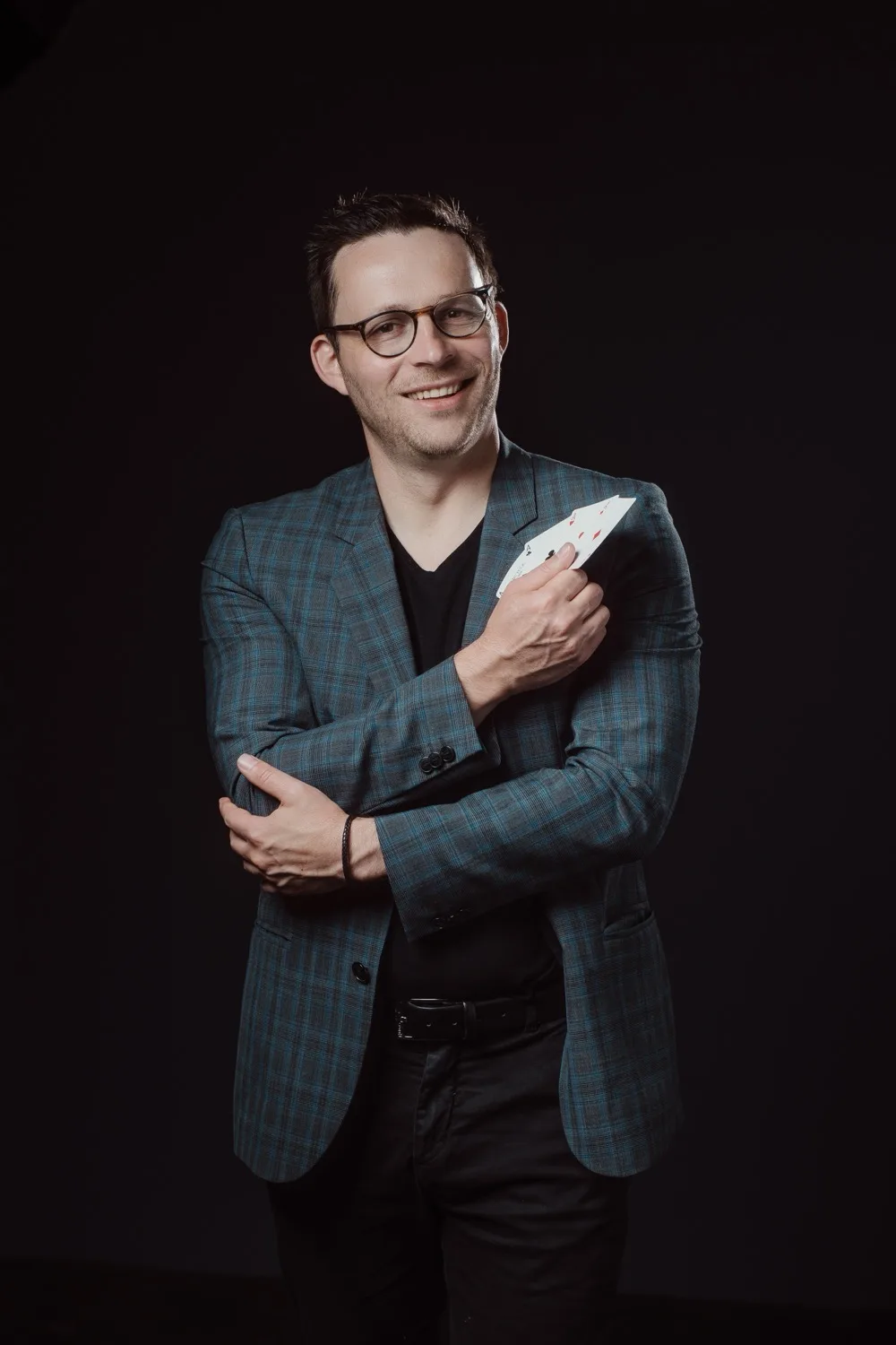 Hugo Marceau, mentalist and AI magician, holding a playing card