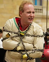 Dean Gunnarson, escapologiste canadien, en camisole de force enchaînée