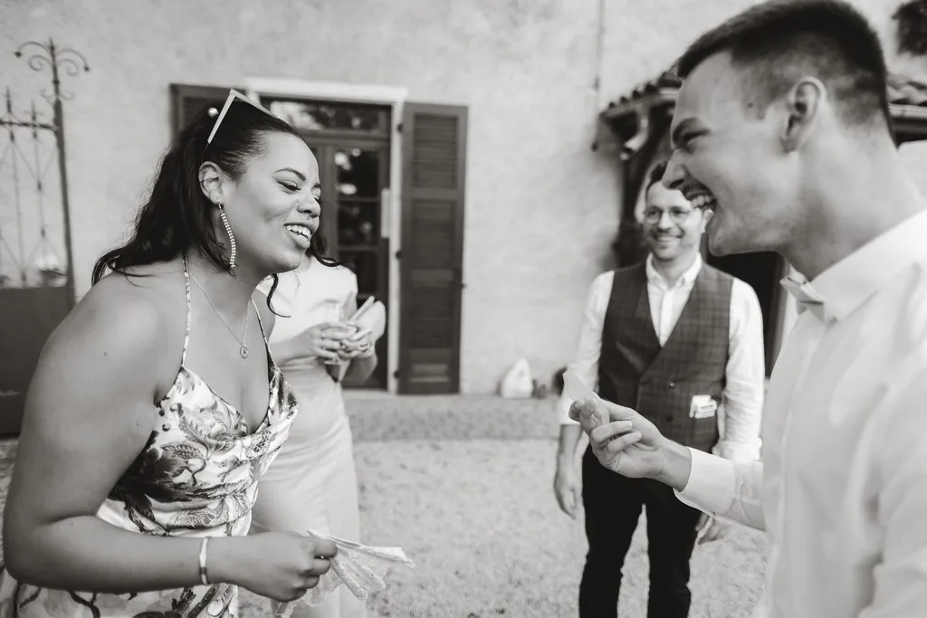 A wedding guest laughing during a close-up effect by Hugo Marceau at the drinks reception