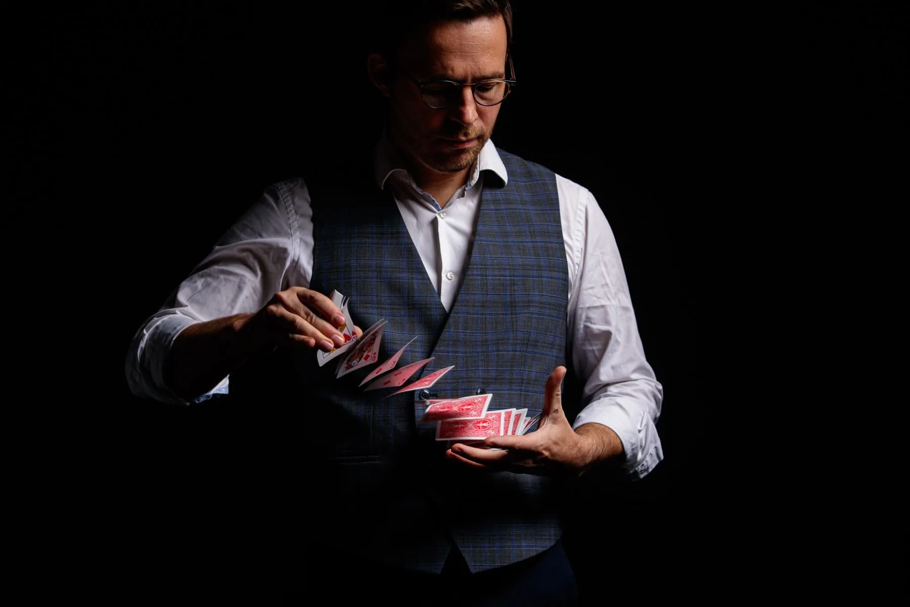 Hugo Marceau, illusionniste, manipule un jeu de cartes en close-up lors d'une démonstration