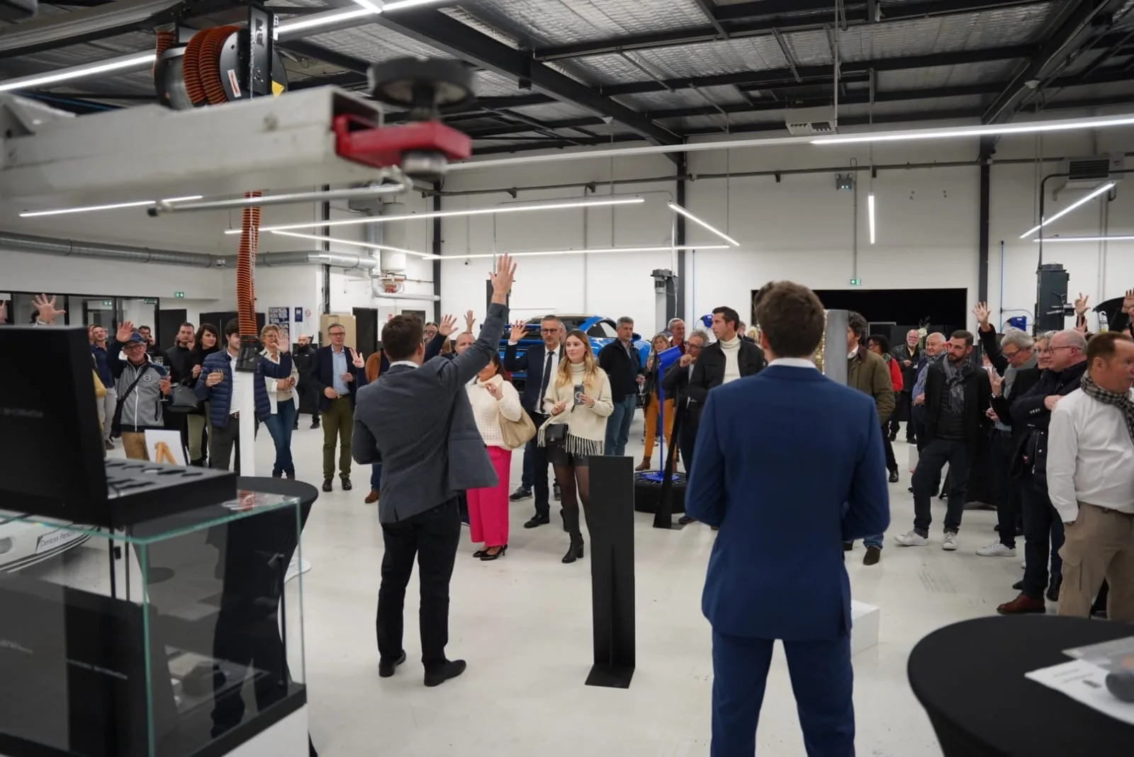 Hugo Marceau magicien mentaliste en plein spectacle scénique d'entreprise, audience corporate participative les mains levées dans un showroom